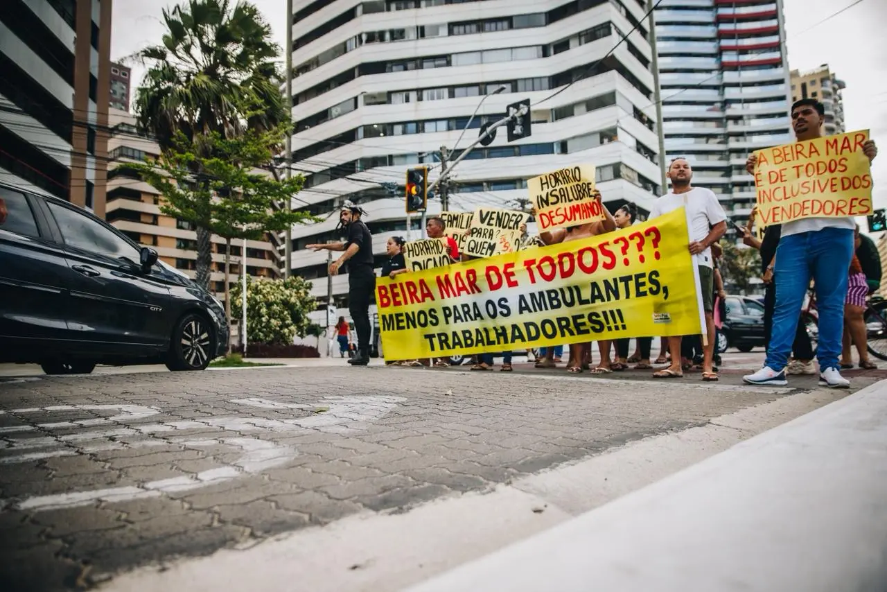 Vendedores se reúnem em protesto com cartazes na Avenida Beira-Mar, em Fortaleza