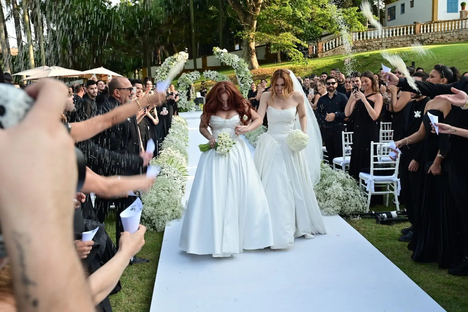 Foto mostra Mari e Júlia saindo do altar.