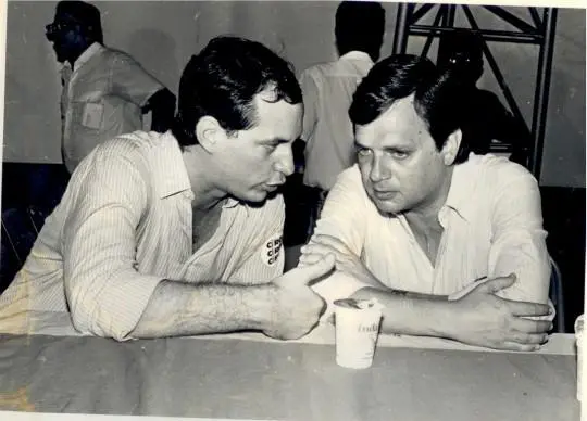 Em imagens antiga, em preto e branco, Ciro ao lado de Tasso no início de sua carreira política. Eles estão encostados em uma mesa conversando