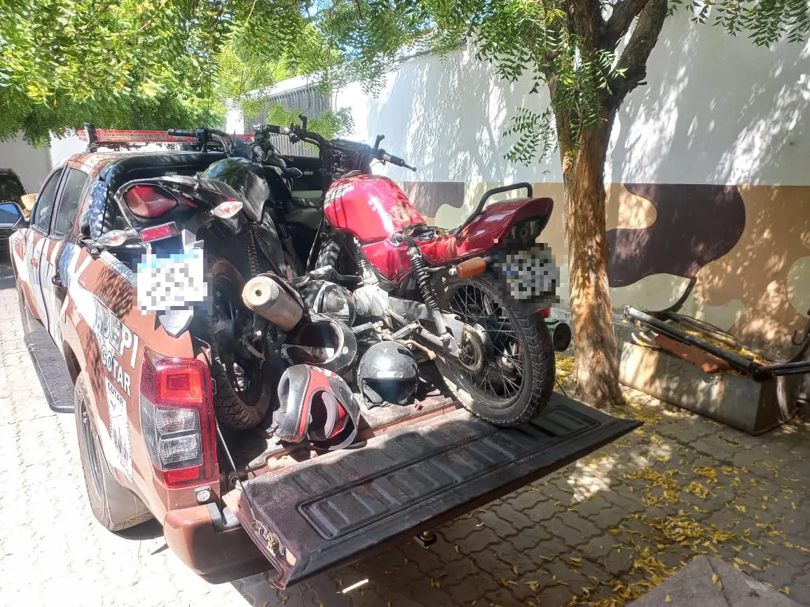 A imagem mostra motocicletas apreendidas pela Polícia, em cima de uma viatura policial.