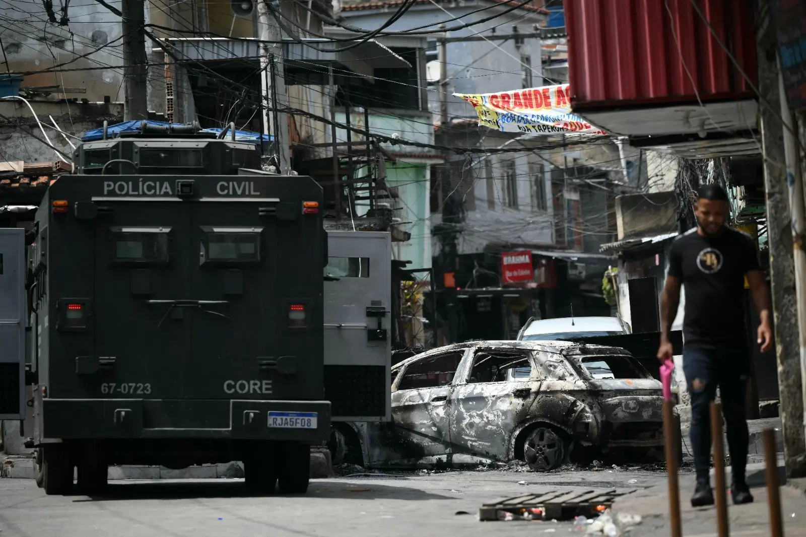 Tanque adentra uma comunidade no Rio de Janeiro, e encontra carros queimados formando uma barricada.