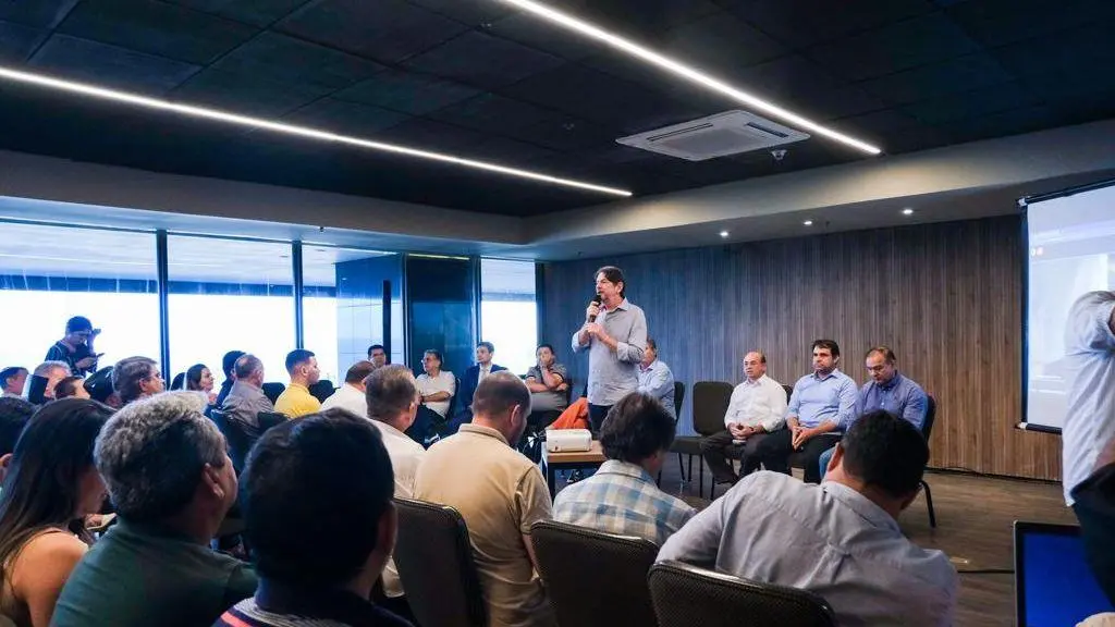 Cid Gomes discursa em auditório. Ao lado dele, deputados estaduais e federais.