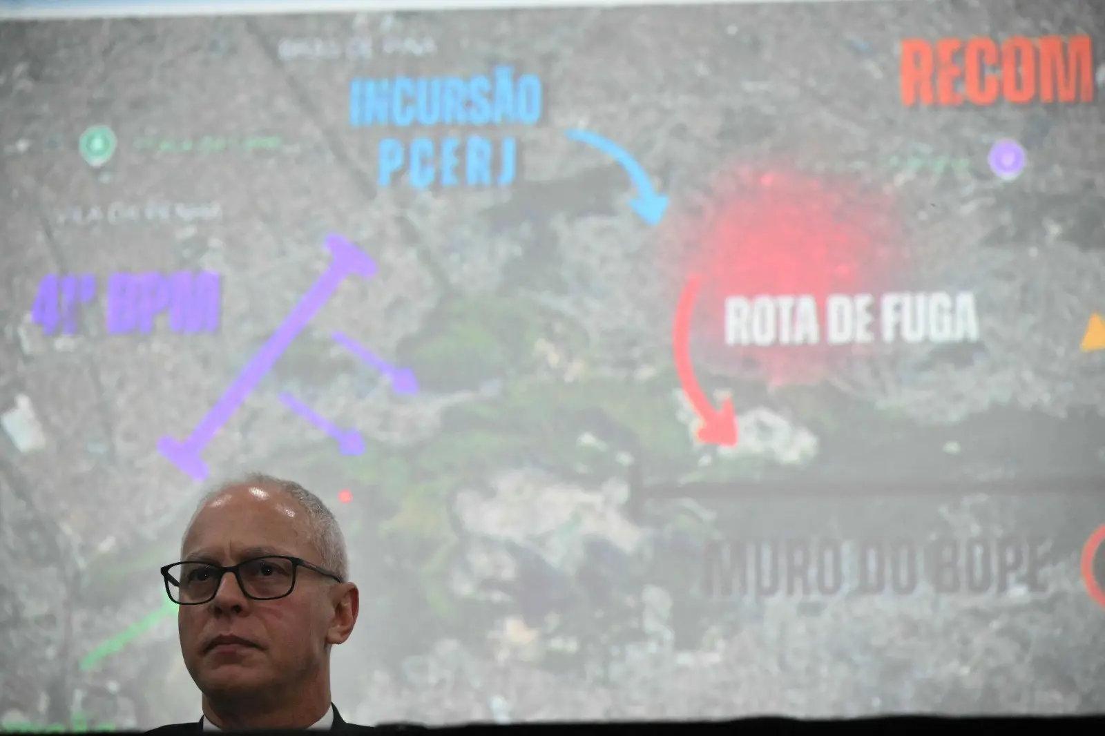 O secretário de Segurança Pública do Rio de Janeiro, Victor Santos, fala em coletiva. Imagem usada em matéria informando que moradores retiraram roupas camufladas dos corpos após operação.