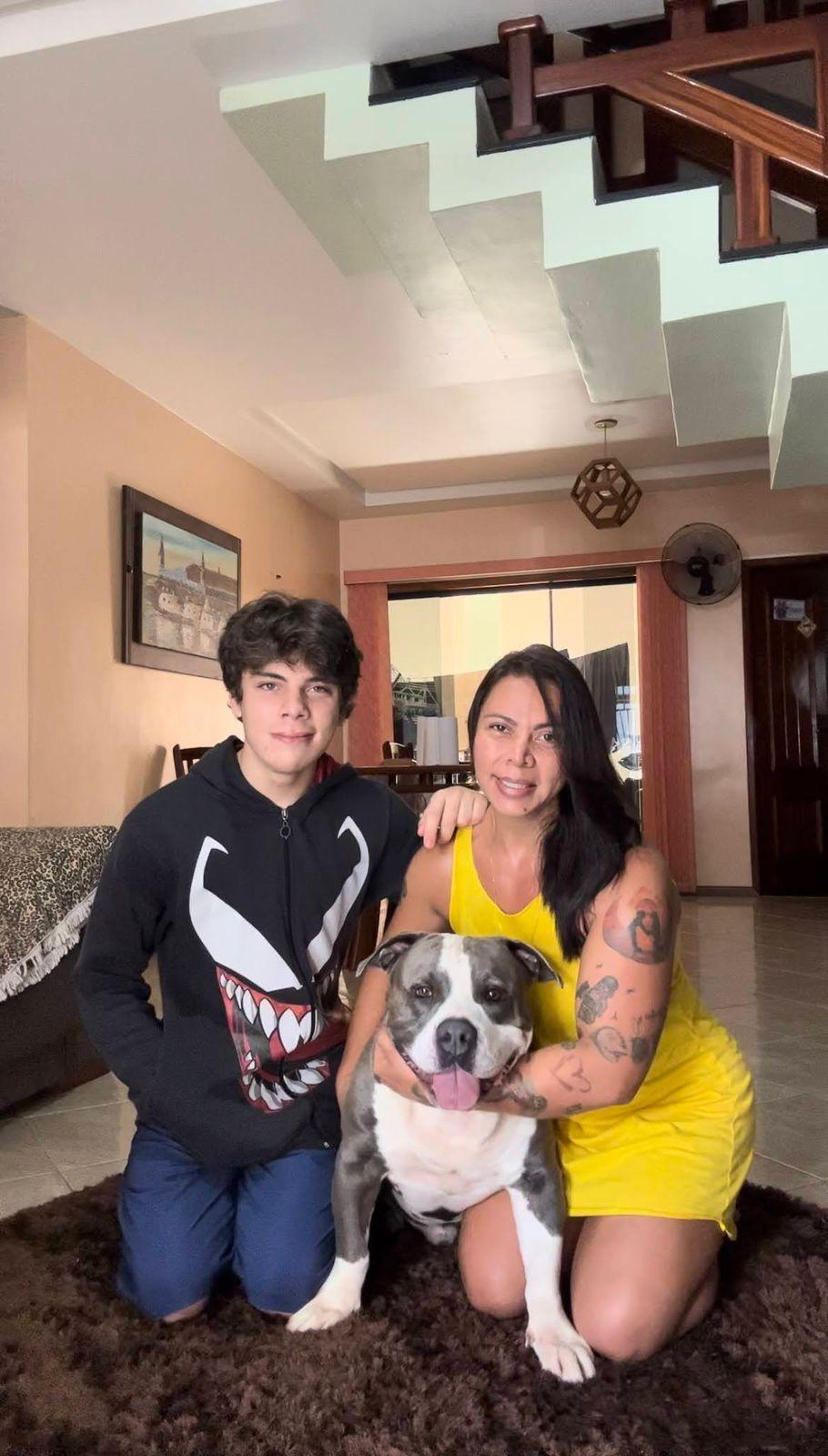 Família comseu cachorro bonito dentro de casa, sorriso e alegria, decoração moderna e ambiente acolhedor na sala.