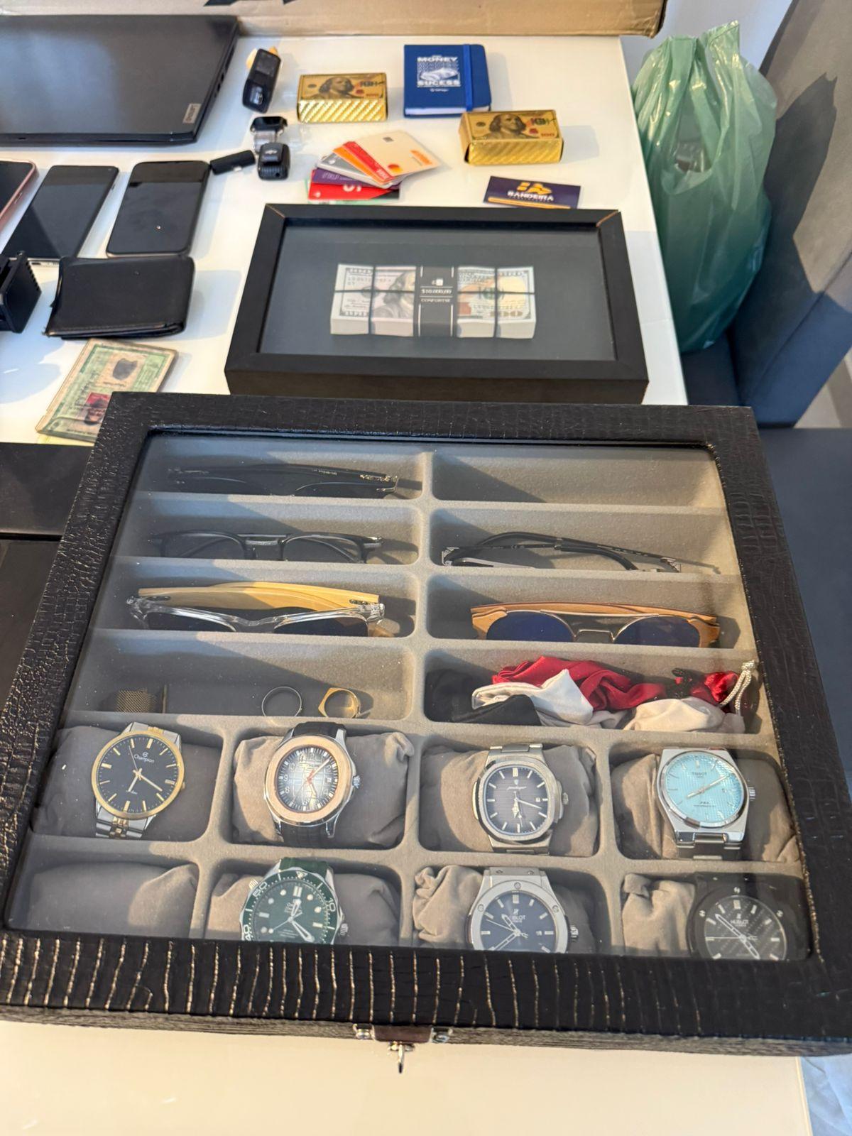 A imagem mostra bens apreendidos durante a Operação Endpoint, do Ministério Público, como relógios e celulares.