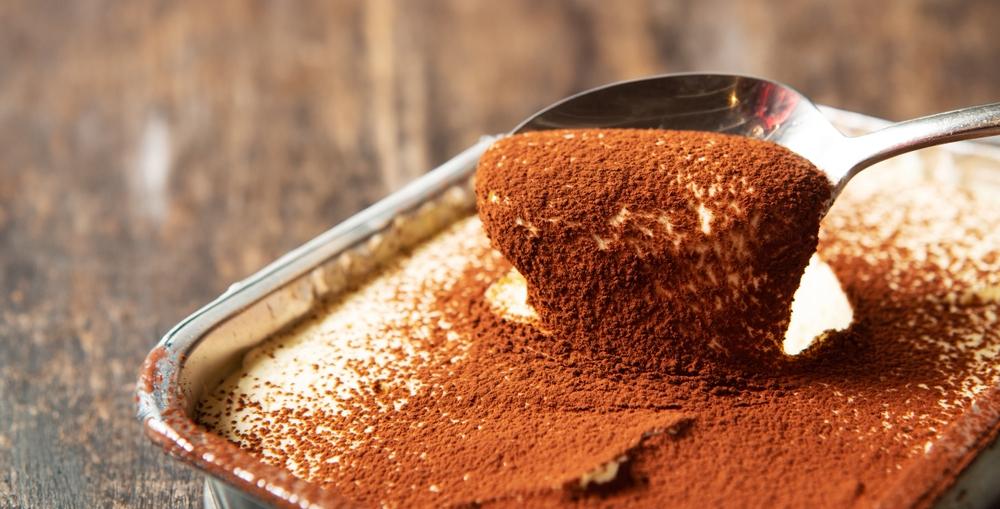 Tiramisú em travessa com chocolate em cima.