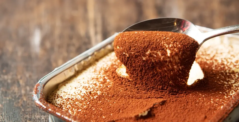 Tiramisú em travessa com chocolate em cima.