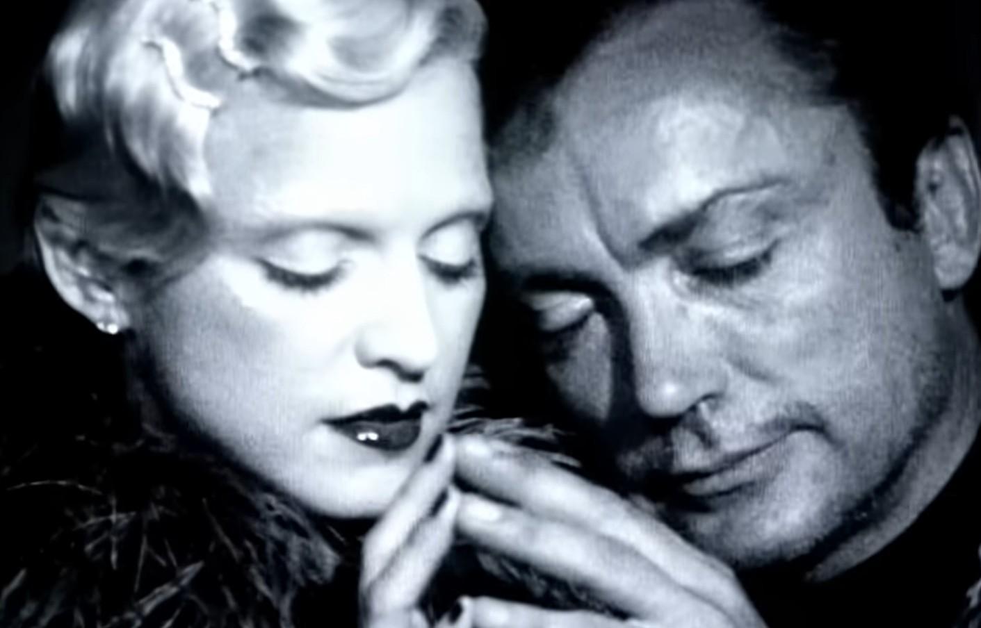 Udo e Madonna no clipe de deeper and deeper, tocando a ponta dos dedos um do outro.