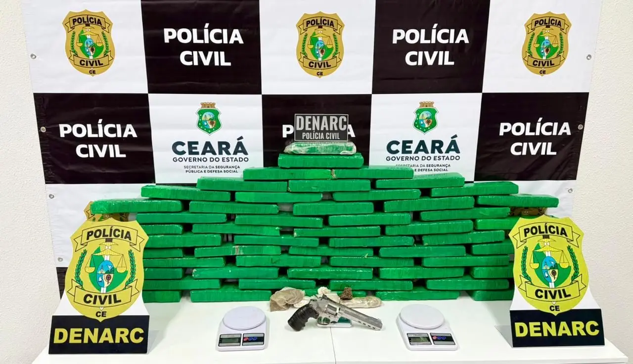 A imagem mostra uma arma de fogo, balanças de precisão e 40kg de maconha embalados, durante operação policial deflagrada pela Delegacia de Narcóticos (Denarc), representada na imagem por brasões.