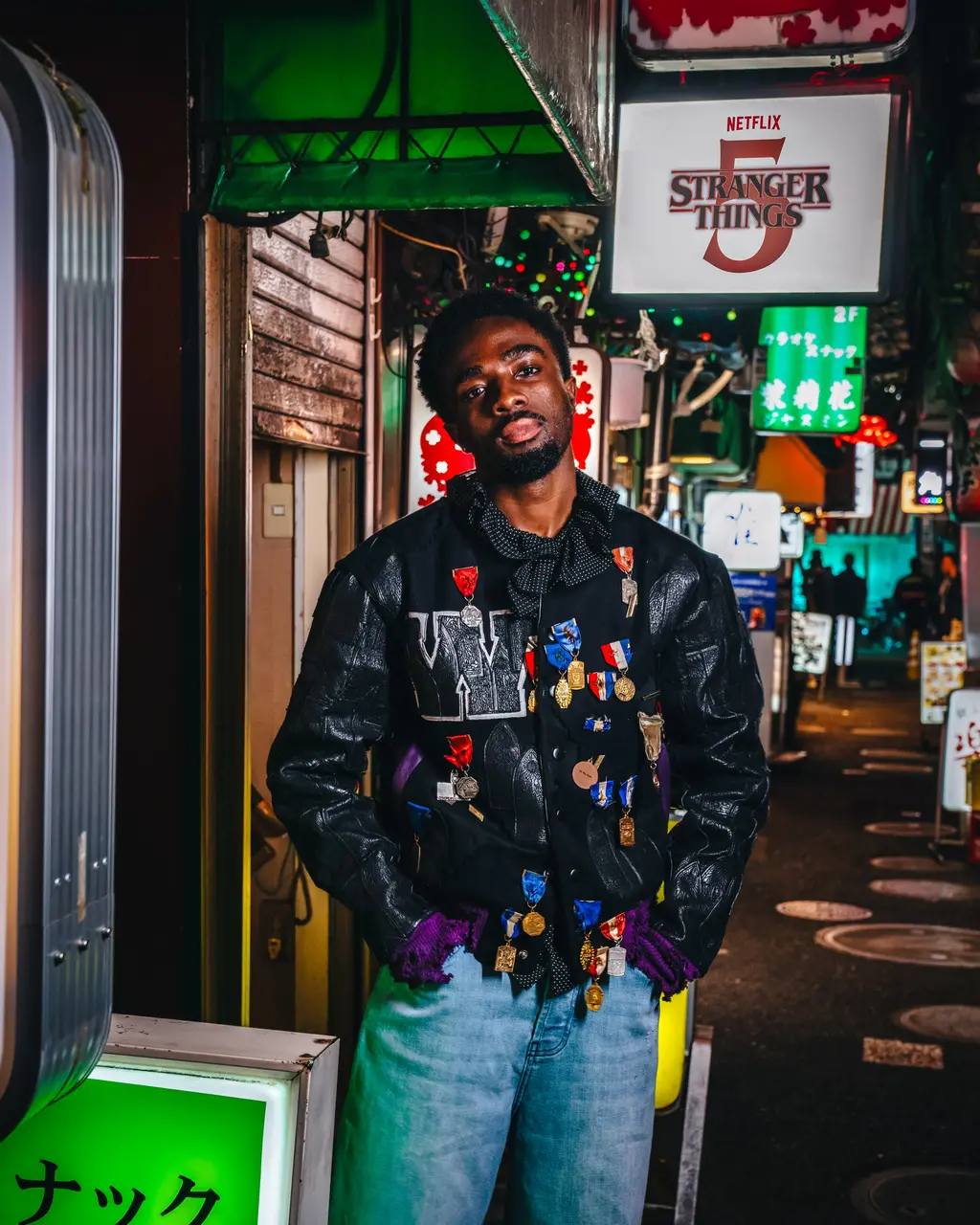 Caleb McLaughlin com calça jeans e jaqueta de couro para foto da Netflix.