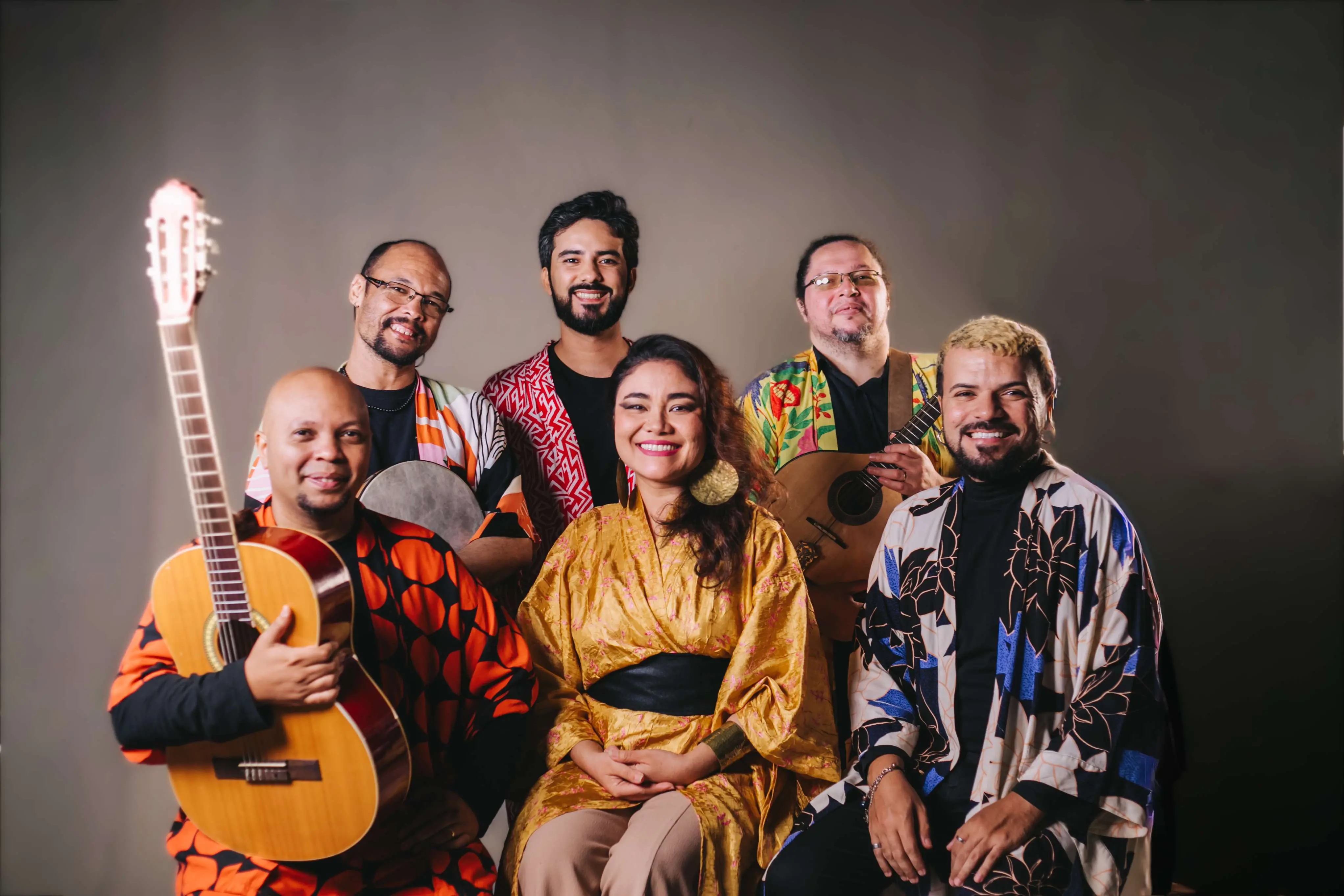 A imagem, que parece ser um retrato promocional de estúdio, apresenta seis artistas do projeto 