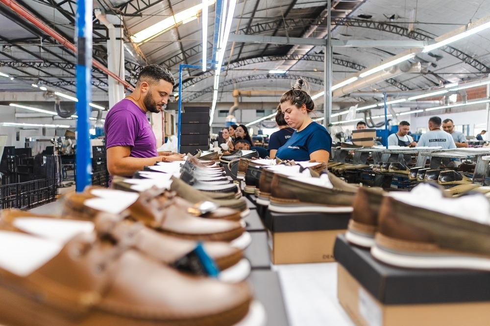 Funcionários trabalham em uma linha de produção de calçados.