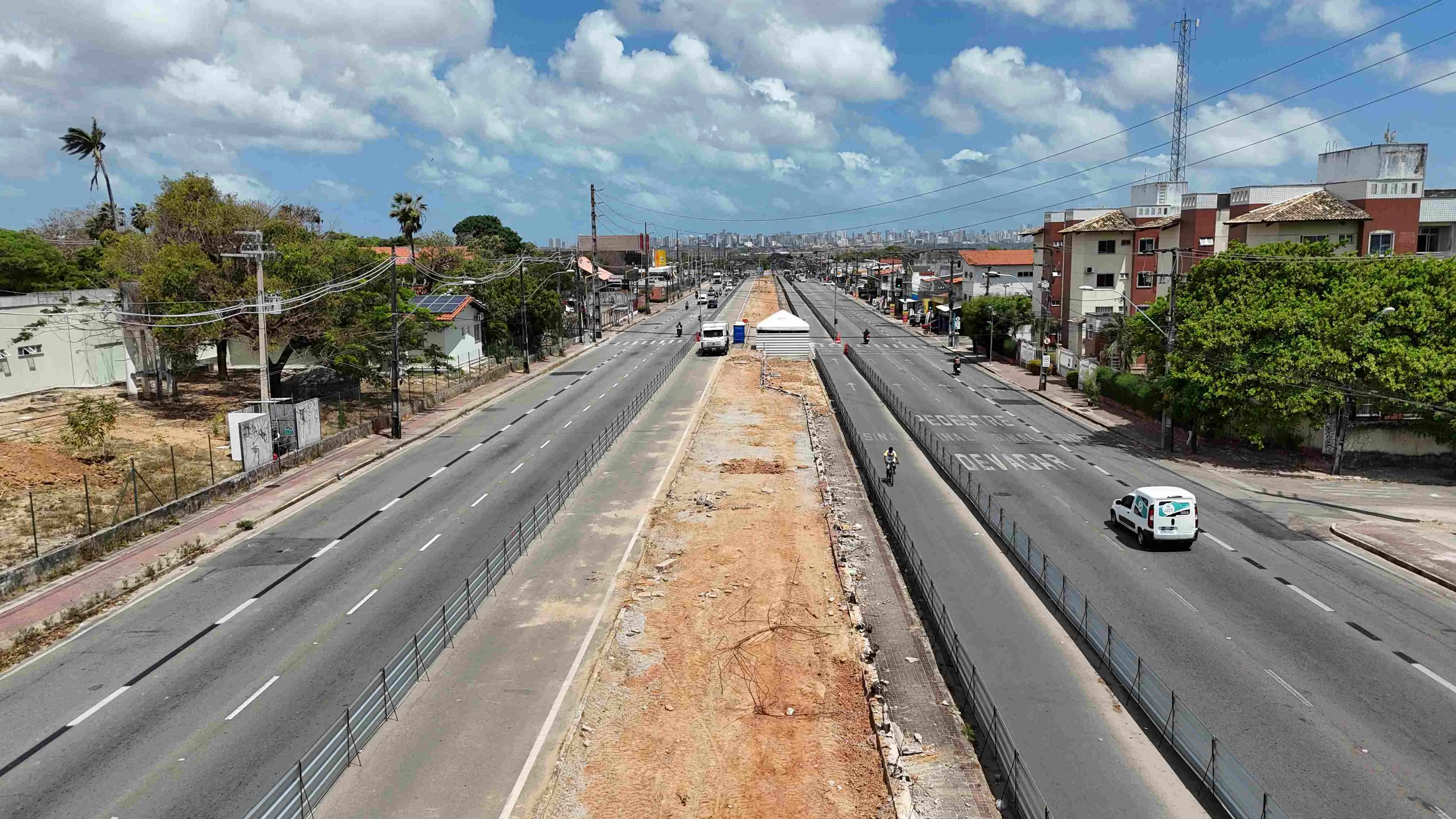 Vista aérea da área interditada na avenida Alberto Craveiro. A ciclofaixa, em seus dois sentidos, está ao lado do canteiro, protegida por tapumes.