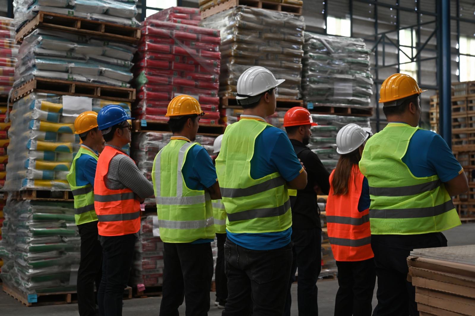 Trabaçhadores de uma fábrica de costas.