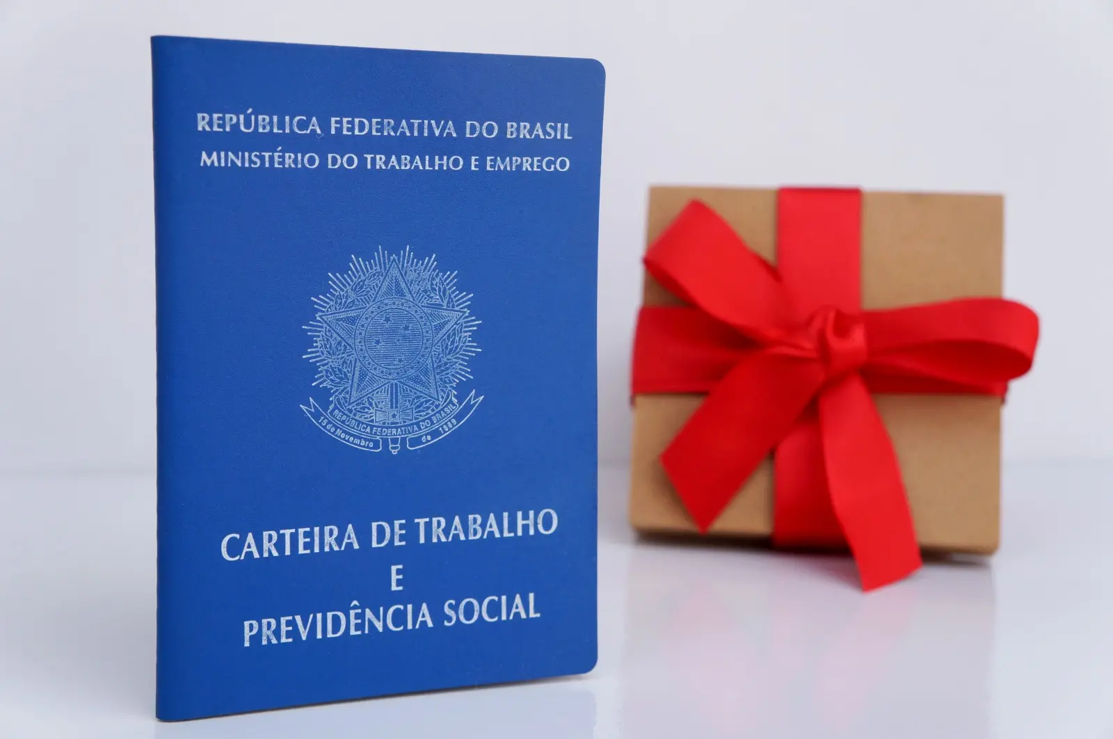 Carteira de trabalho com um presente de Natal no fundo.