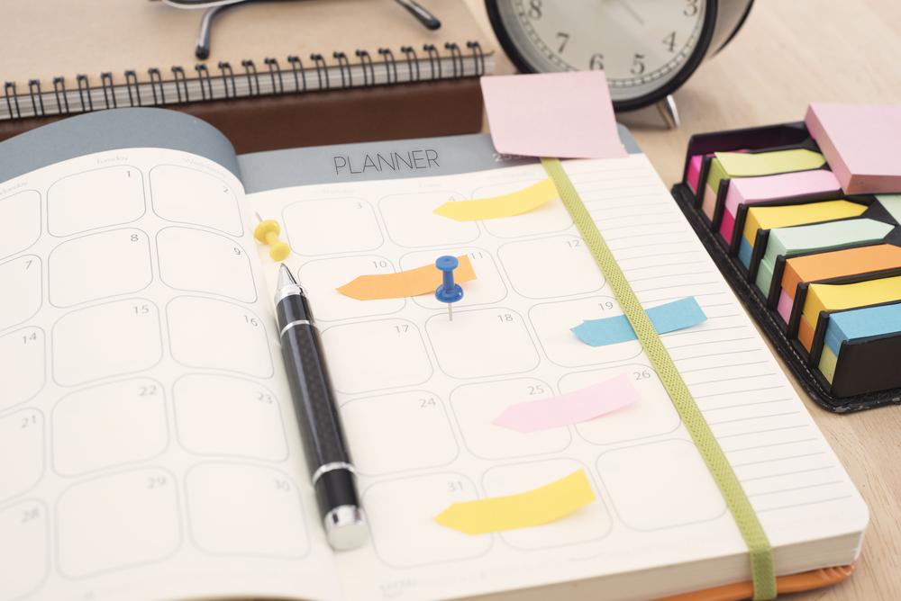 foto de planner com etiquetas e canetas.