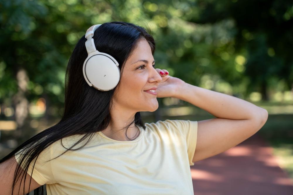 foto de mulher em parque com fones de ouvido.