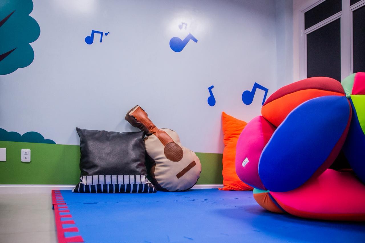 Espaço com almofadas e decoração musical para estimulação sensorial.