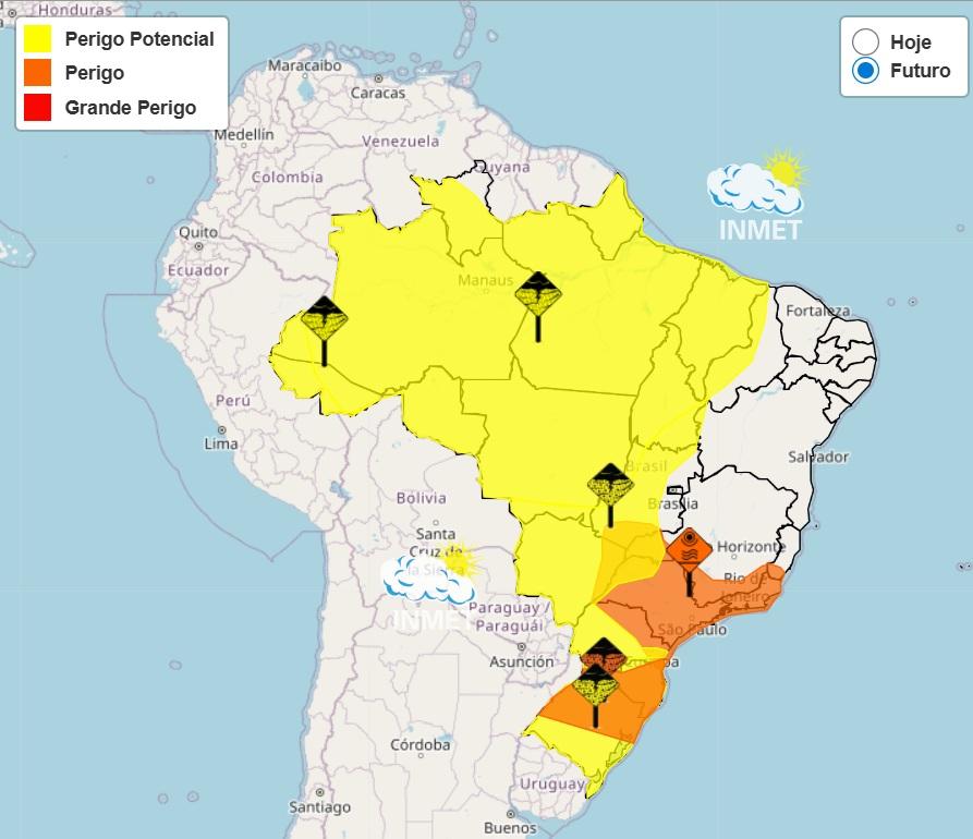 Mapa da América do Sul com destaque para o Brasil, mostrando áreas de risco meteorológico segundo o INMET. A legenda indica três níveis: Perigo Potencial (amarelo), Perigo (laranja) e Grande Perigo (vermelho). A maior parte do Brasil aparece em amarelo, cobrindo regiões Norte, Centro-Oeste e parte do Sudeste. Há áreas em laranja principalmente no Sudeste e Sul, incluindo regiões próximas a São Paulo, Rio de Janeiro e Paraná. Ícones de alerta meteorológico estão distribuídos em algumas áreas. No canto superior direito, há a opção “Hoje” e “Futuro”, com “Futuro” selecionado, além do logotipo do INMET.