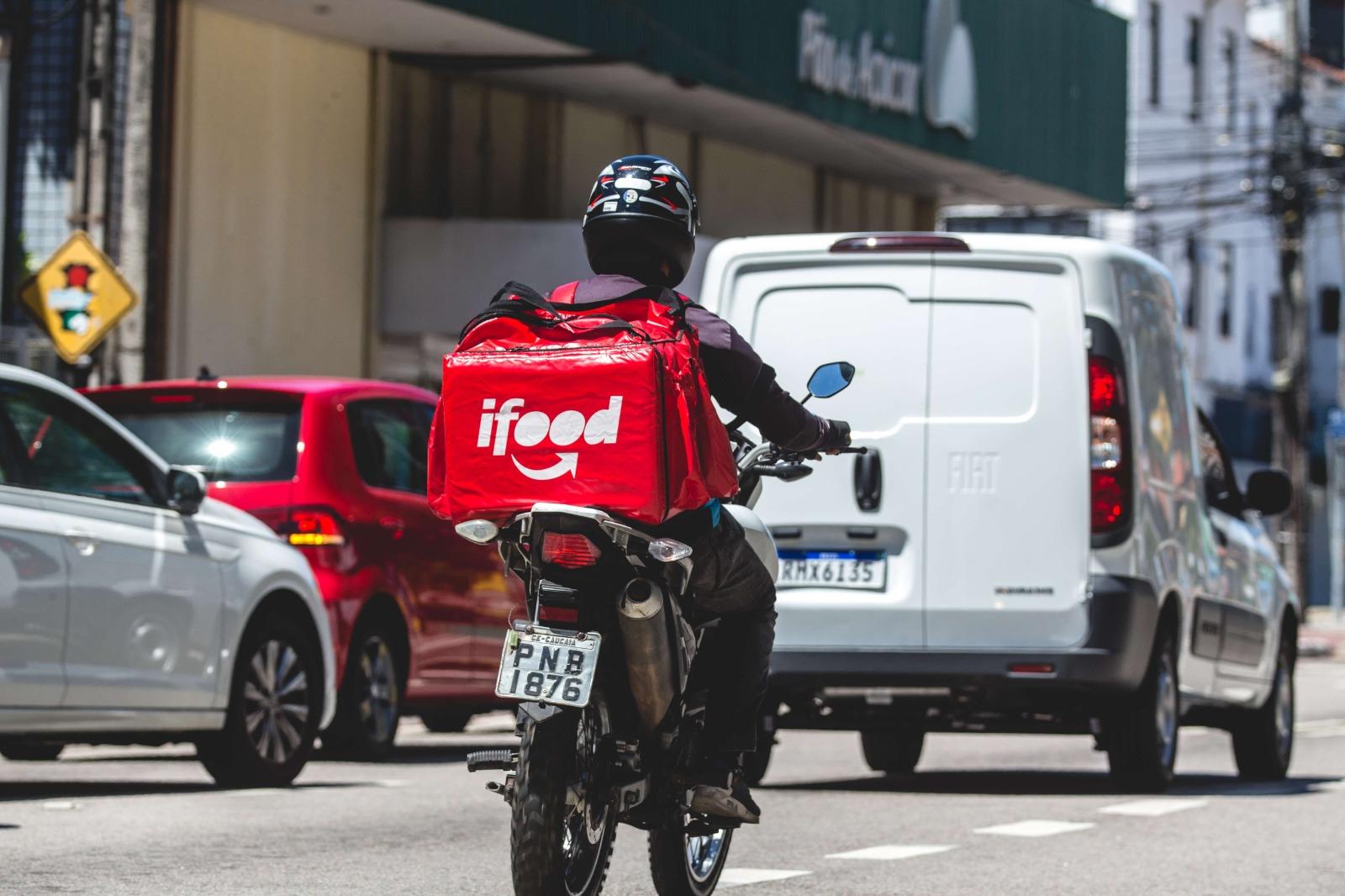Foto de motociclista do Ifood no trânsito.