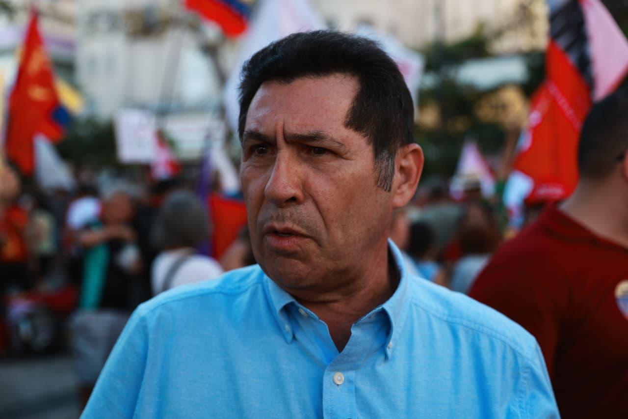 Líder do Governo Elmano de Freitas durante ato na Praça do Ferreira. Ele veste uma camisa azul durante a entrevista.