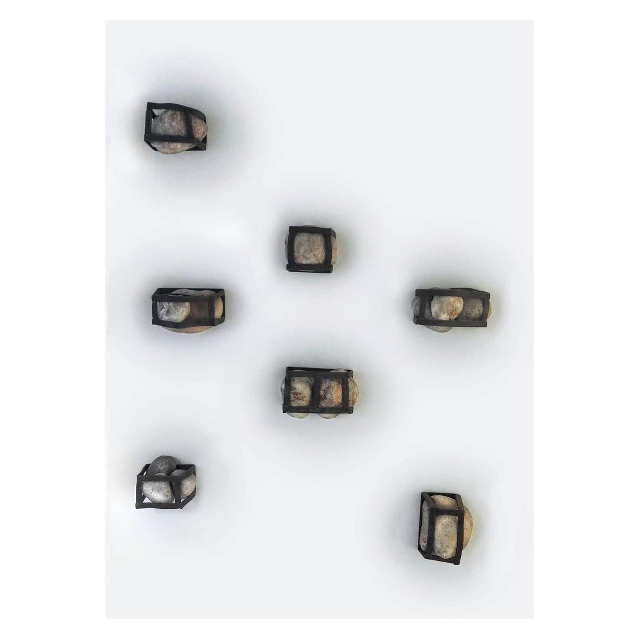 Obra de arte composta por diferentes pedras colocadas em grades de ferro.