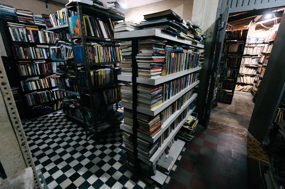 A foto mostra a parte interna do Sebo O Geraldo, onde se encontra diversas prateleiras de livros.