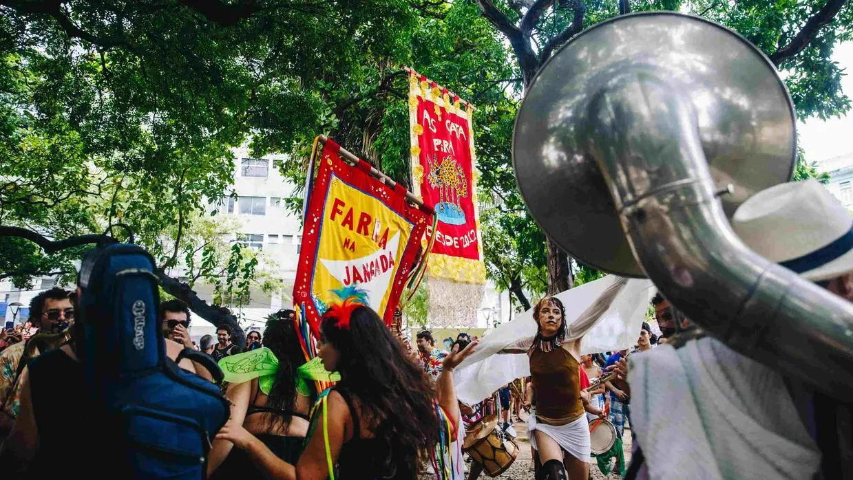 Foliões pulando carnaval de rua.