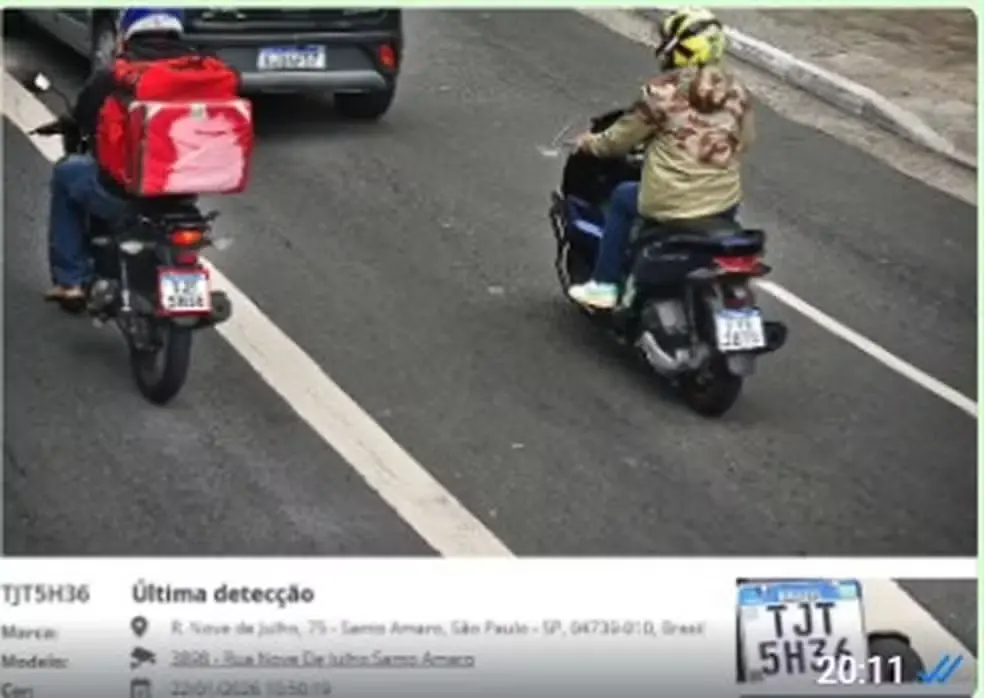 A imagem mostra dois homens trafegando em motocicletas, suspeitos de cometer um assalto.