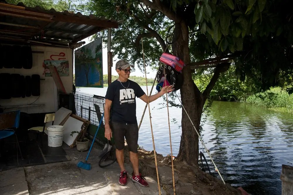 Na imagem, um homem de pele clara e meia-idade, vestindo camiseta preta com a logomarca 