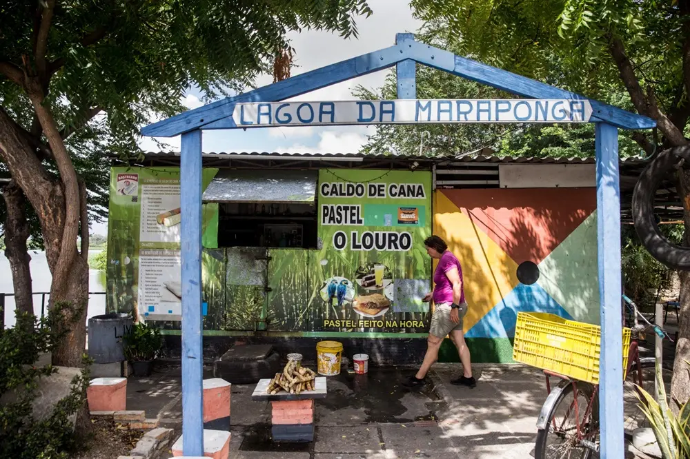 Na imagem, uma barraca de lanches colorida e rústica, chamada 