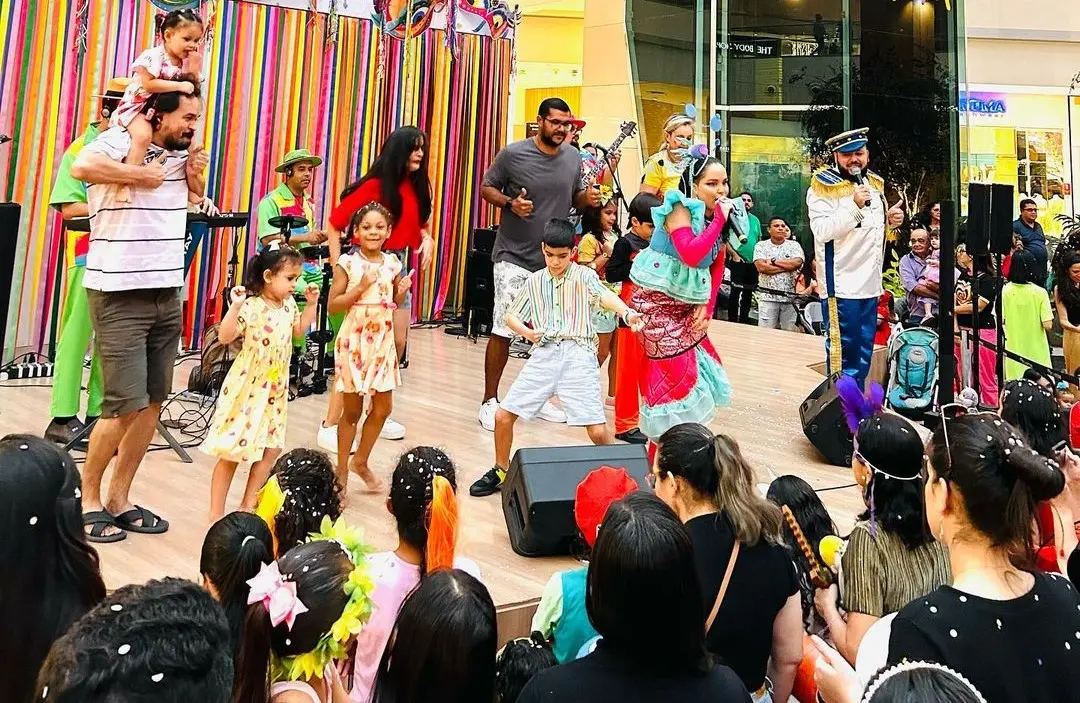 Adultos e crianças pulando carnaval em um shopping na cidade de Fortaleza.
