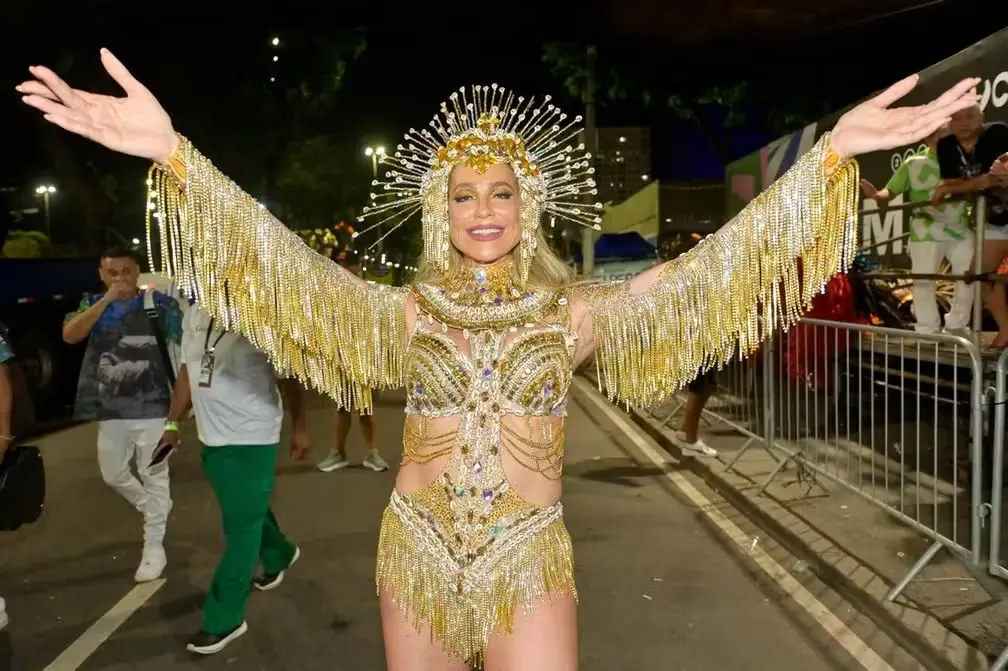 Luana Piovani posa de braços abertos, com fantasia dourada.