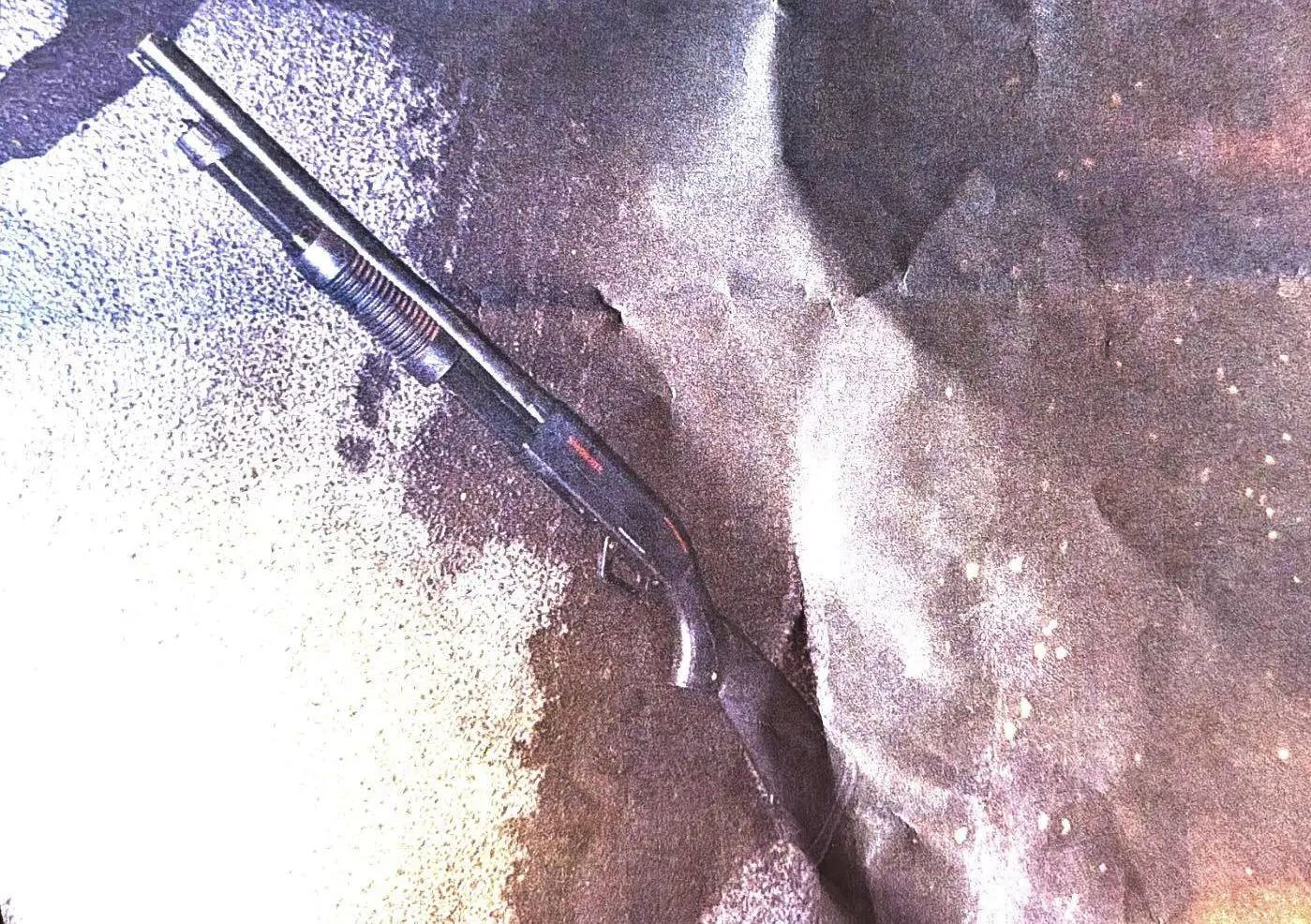 Escopeta no chão em uma foto feita e impressa em papel.