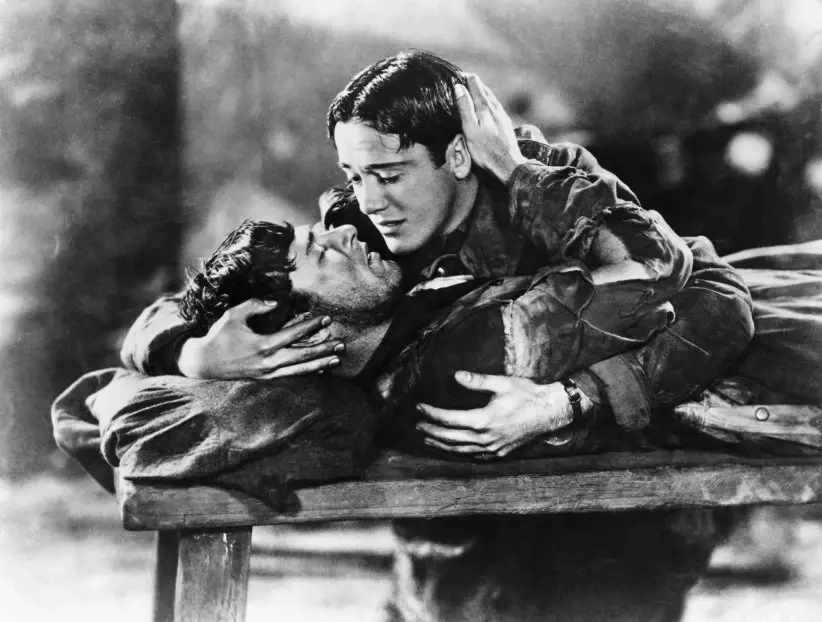 Imagem clássica do filme 'Asas' mostrando dois personagens em uma cena de romance e carinho, retratando uma história de amor