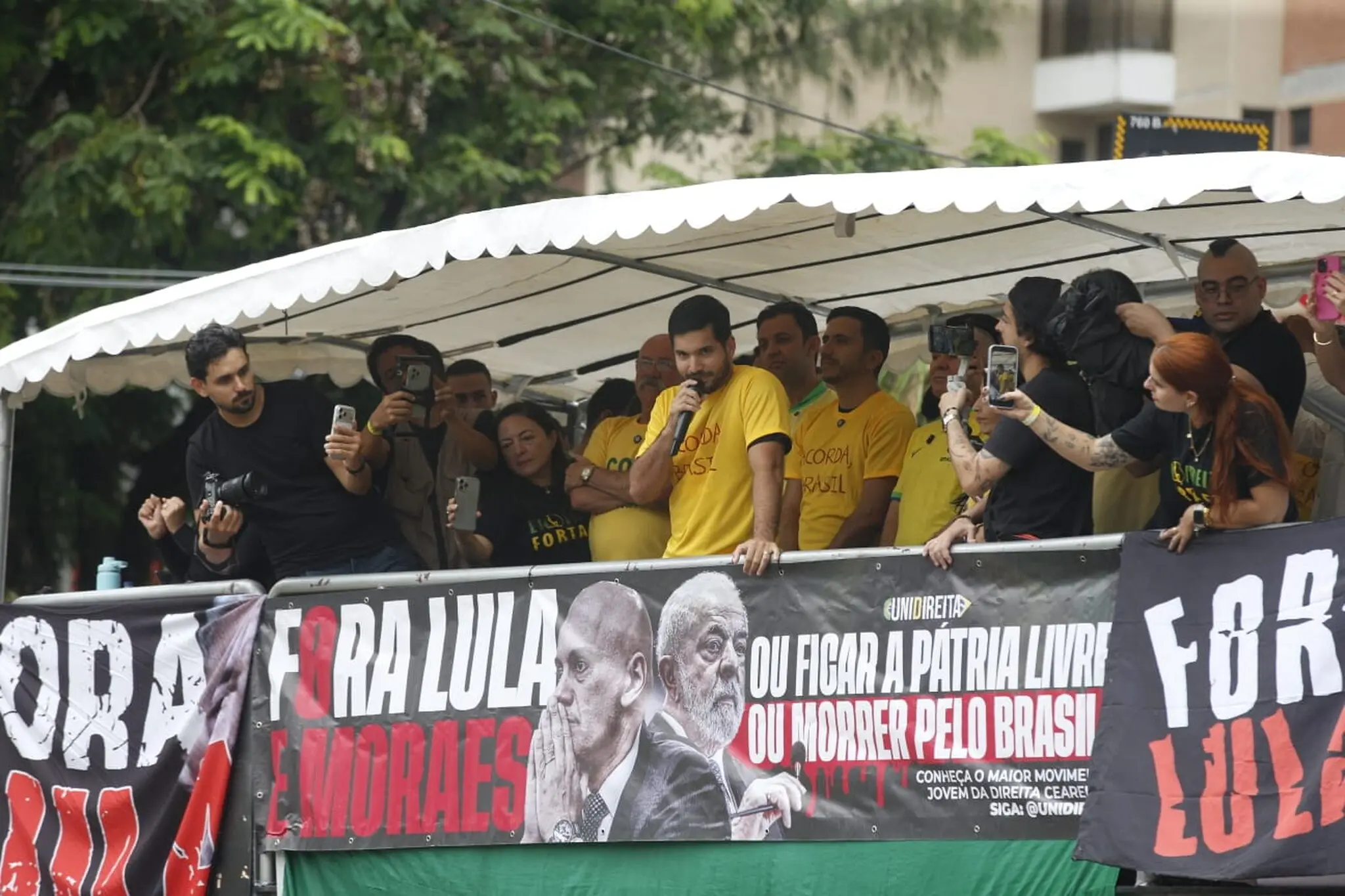 Políticos em trio elétrico com faixas contra o presidente Lula e ministros do STF.