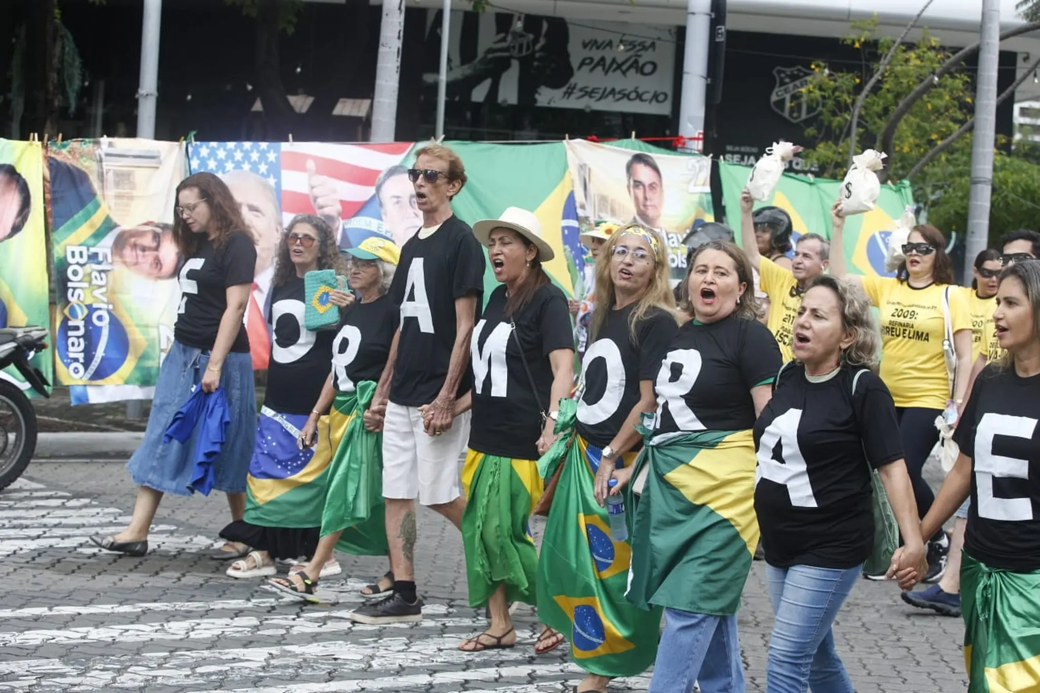 Manifestantes usam blusa preta, cada um carrega uma letra que forma a frase  'Fora Moraes'.