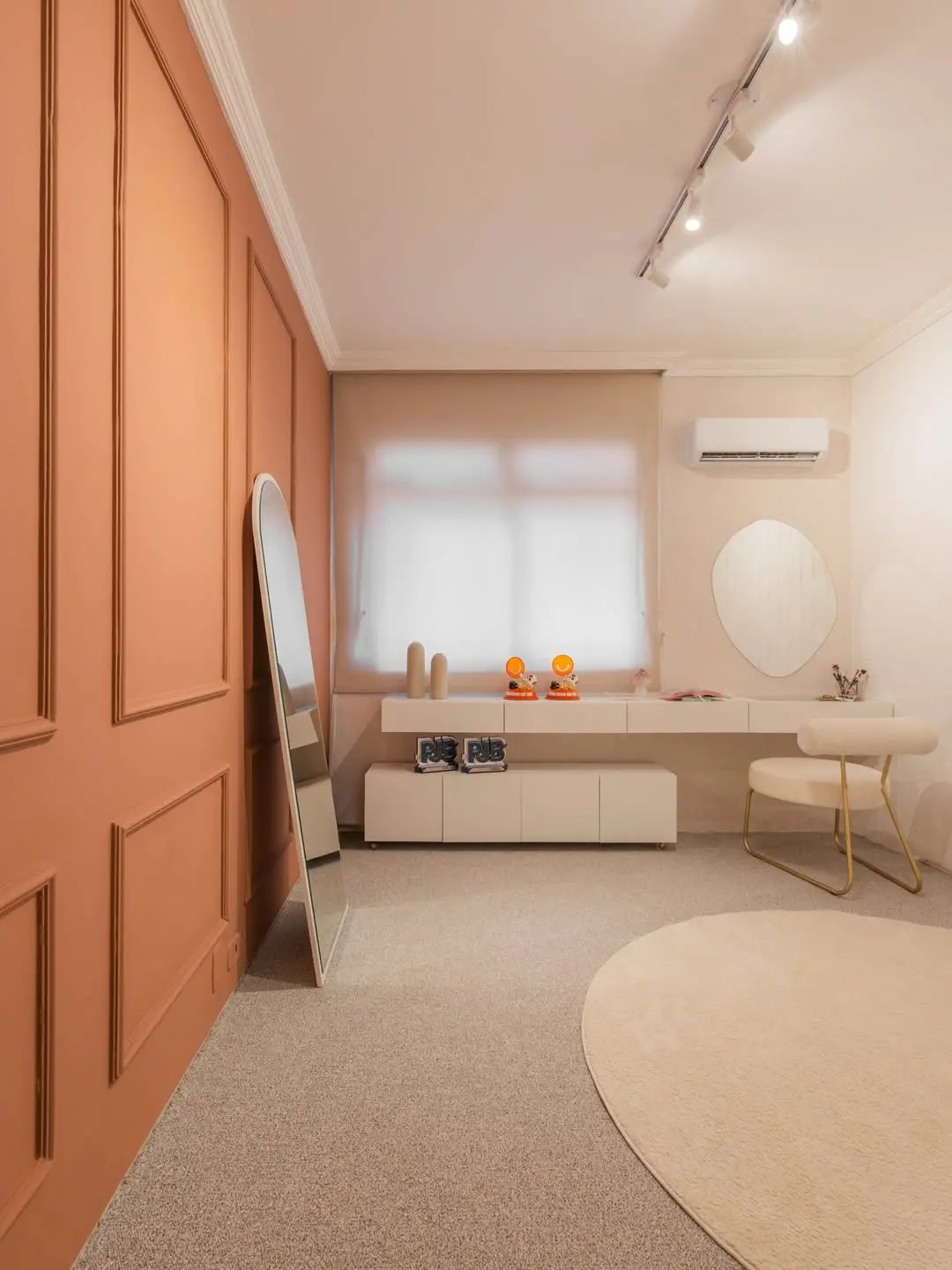 Quarto amplo com penteadeira e espelhos.