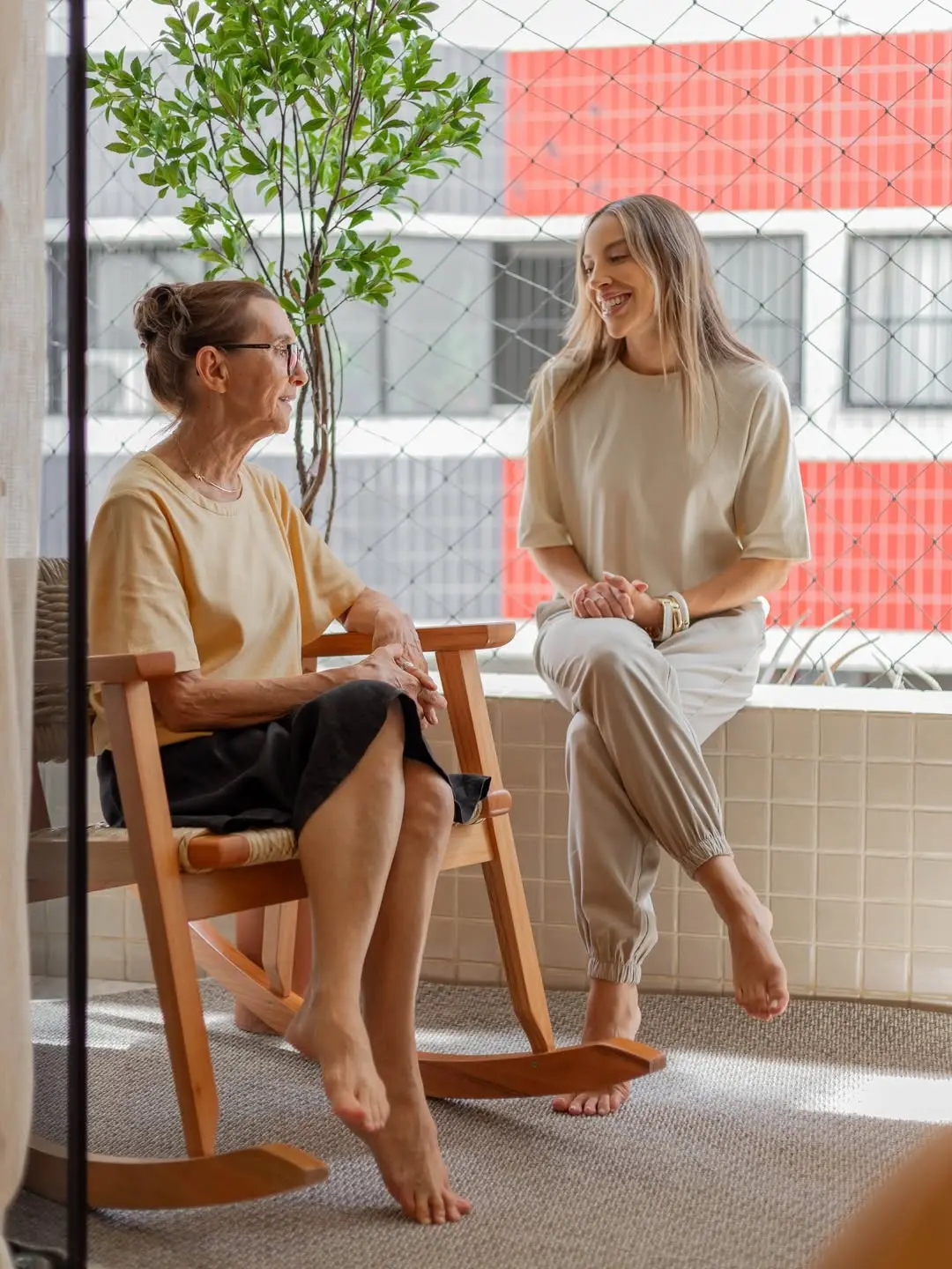 Renata e a mãe sentadas na varanda.