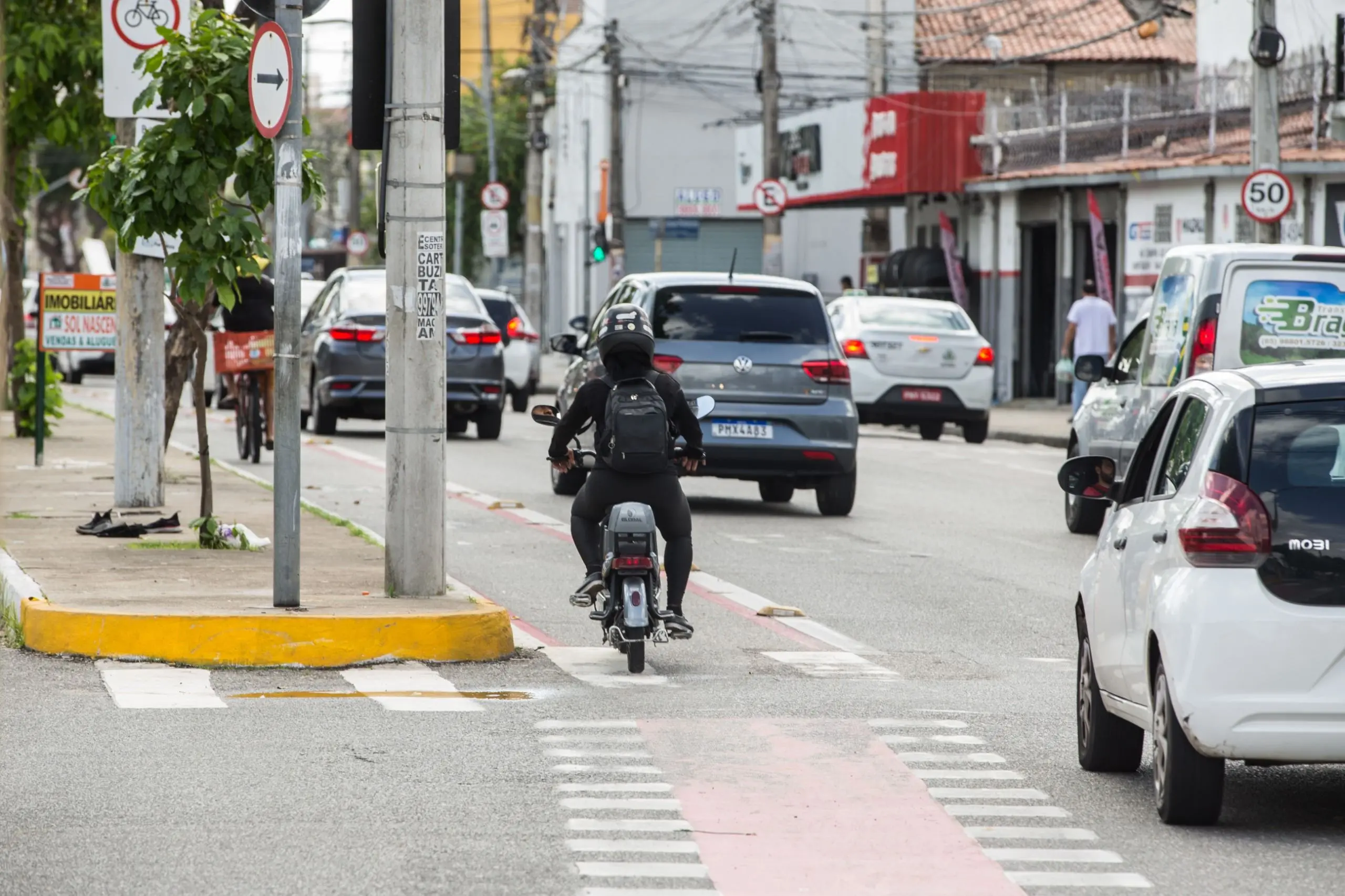 A foto registra o momento em que uma motocicleta invade o espaço exclusivo das bicicletas, agora desprotegido pela ausência das barreiras físicas.