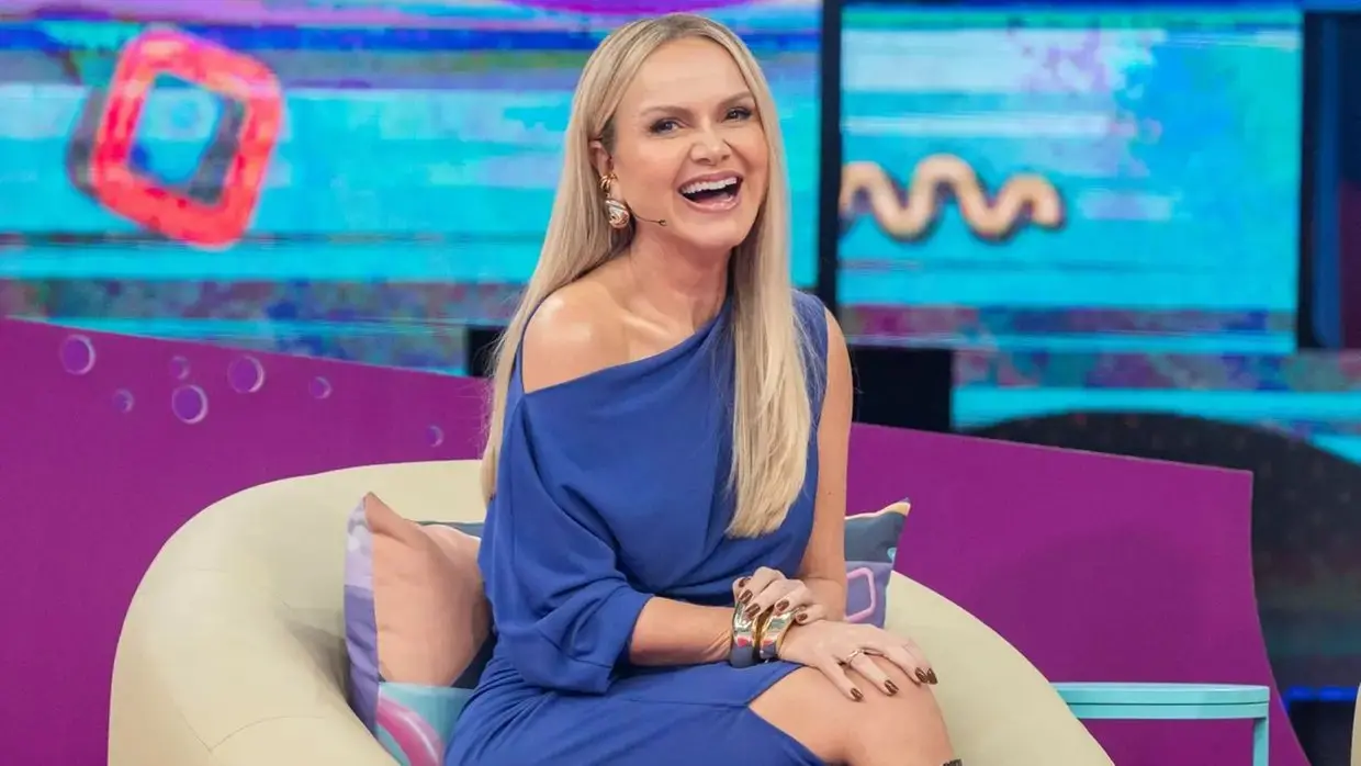 Eliana sentada e sorridente. Ela veste um vestido azul.