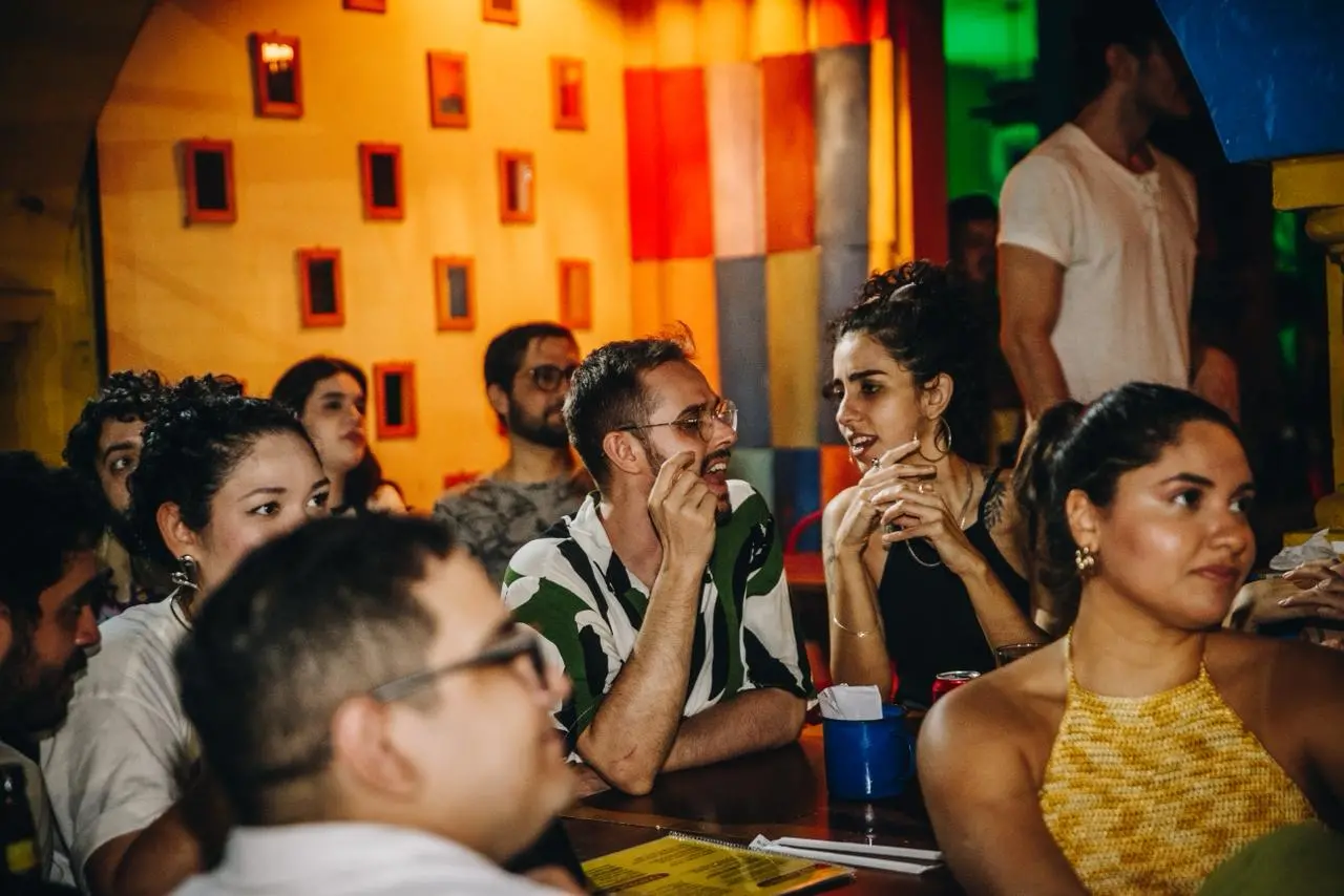 Pessoas em mesa de bar de Fortaleza durante a transmissão do Oscar.