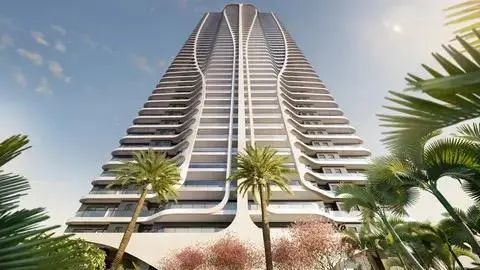 Vista de baixo para cima de edifício residencial de alto padrão em Fortaleza, com arquitetura moderna, varandas curvas e palmeiras ao redor.