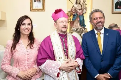 Primeira-dama Lia Freitas, de blusa de renda na cor rosa, aparece ao lado do bispo da diocese de Baturité, Dom Pepeu, que veste trajes eclesiásticos. Na ponta esquerda, está o governador Elmano de Freitas de terno azul e gravata amarela.
