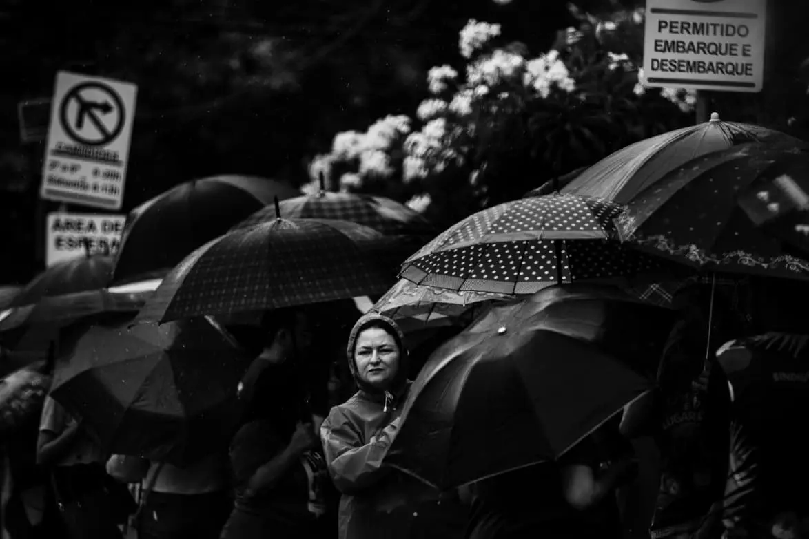 foto em preto e branco mostra populares se protegendo da chuva em Fortaleza.