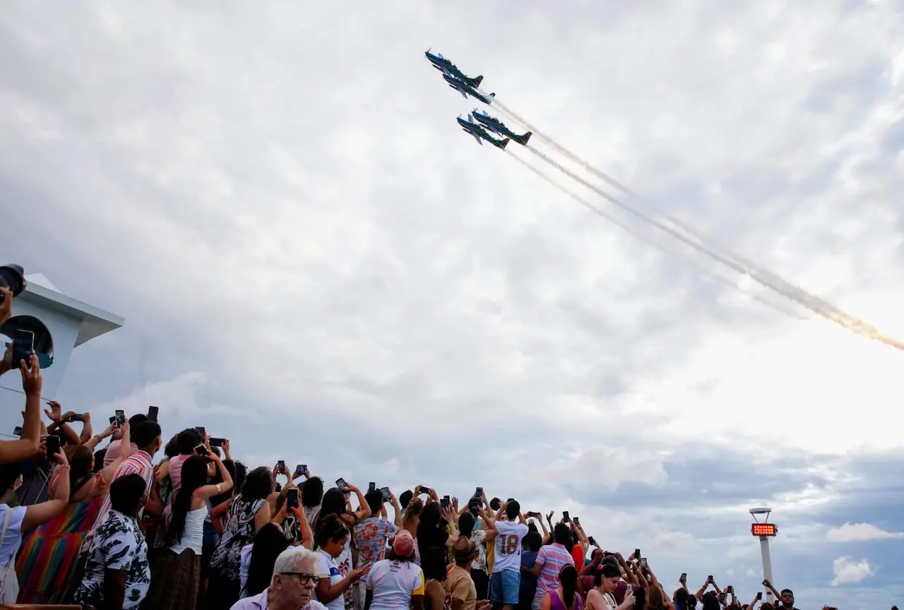 Esquadrilha da Fumaça realiza apresentação aérea com aviões em formação enquanto público observa e registra o espetáculo em Fortaleza.