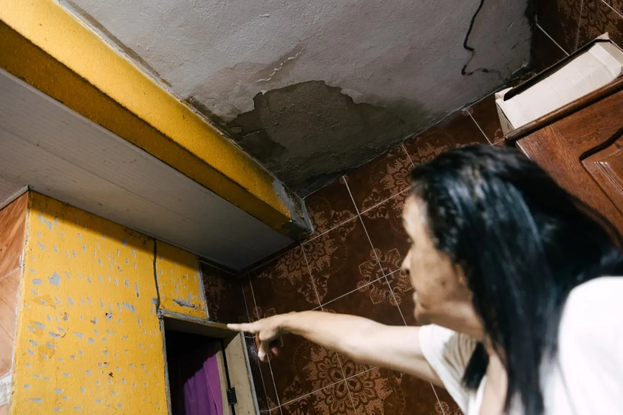 As rachaduras na casa de dona Maria estão no teto e nas paredes, um reflexo das obras que acontecem no terreno logo atrás.