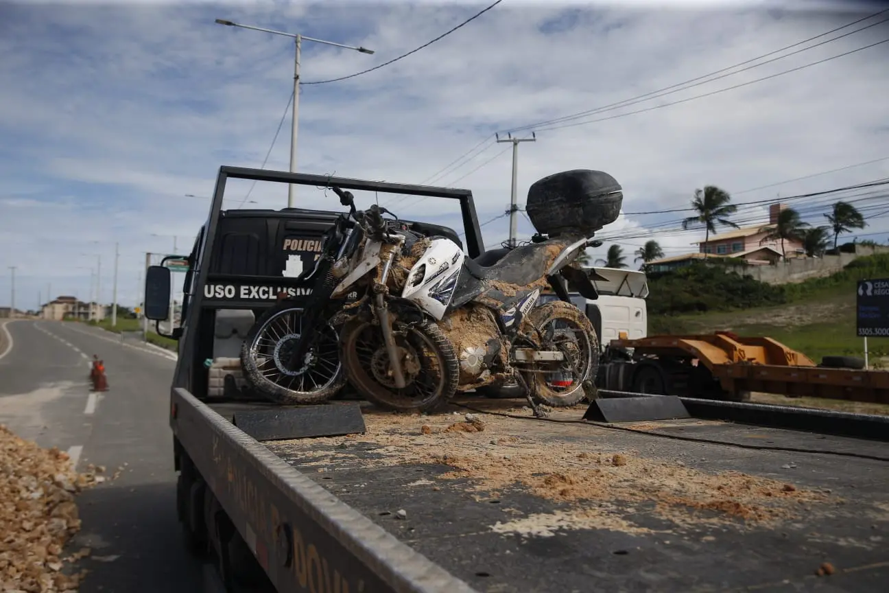 Carro, motos e pertences de vítimas de deslizamento em Aquiraz são retirados de cratera.