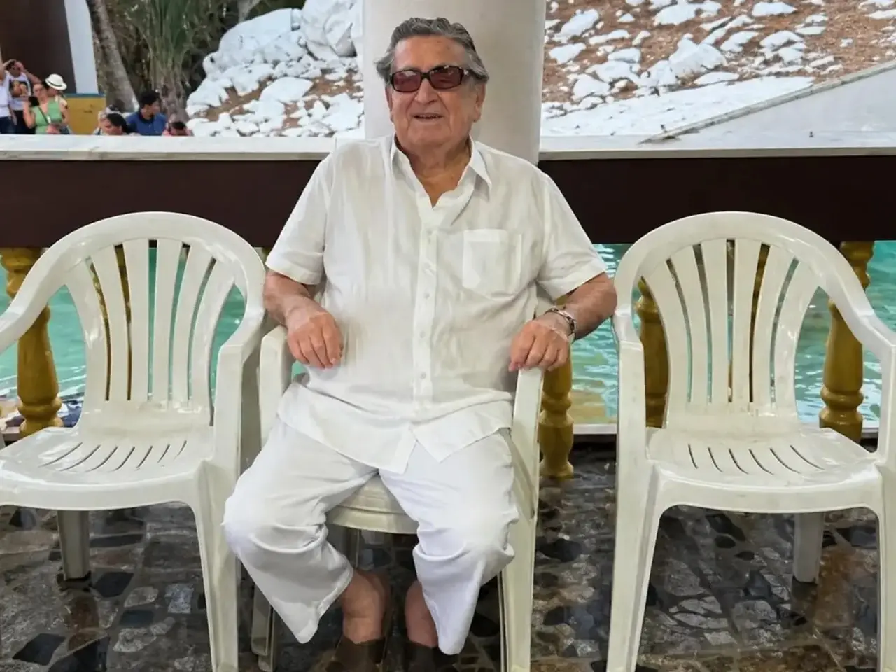 Foto de Ernani de Queiroz Viana sentado em cadeira e vestido de branco.