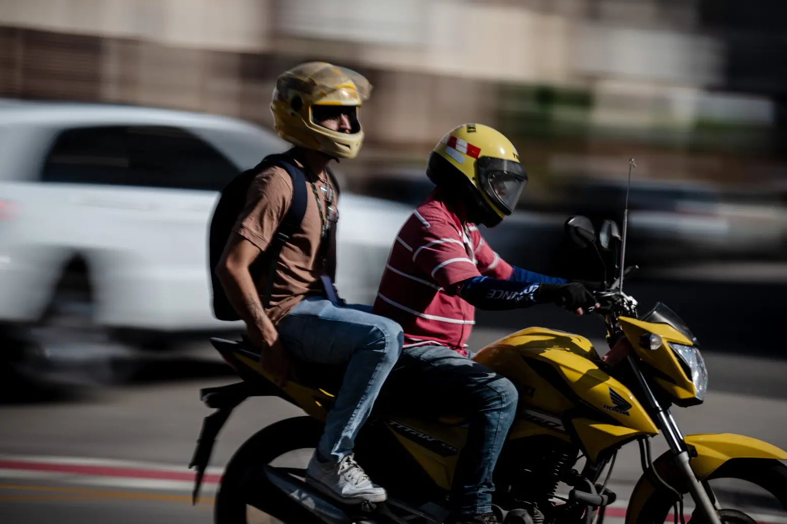 Mociclista de uber moto com passageiro em movimento.